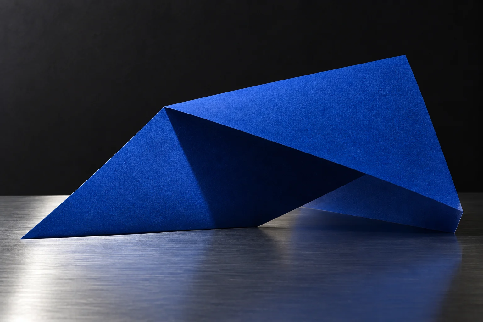 Estudo visual de papel azul dobrado sobre metal